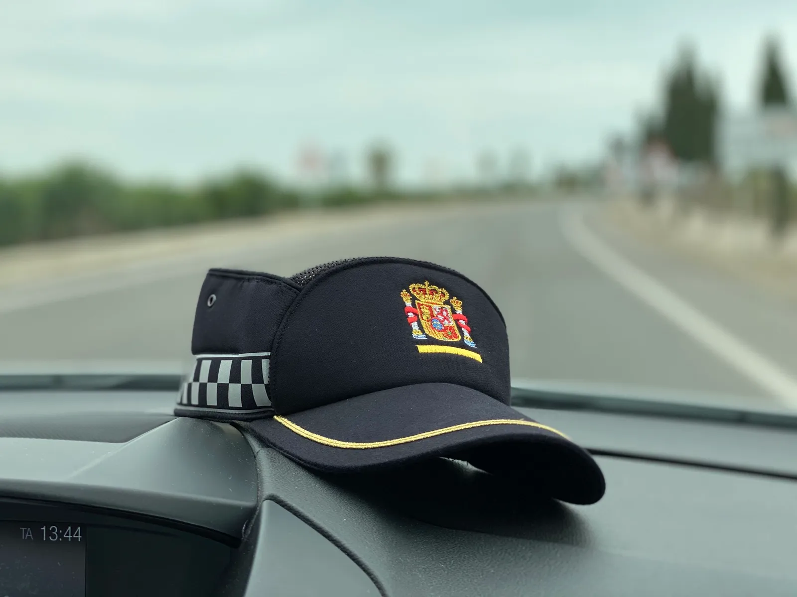 Gorra de Policía Local sobre el salpicadero de un vehículo patrulla